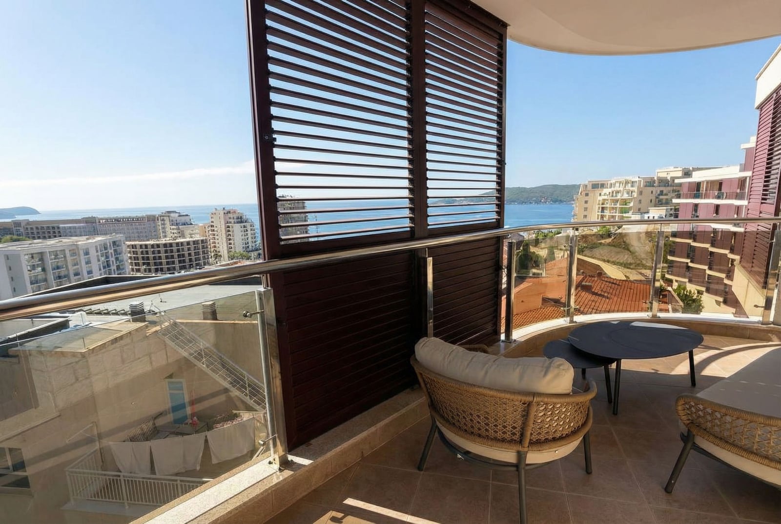 Balcony with wicker furniture and panoramic sea view in an apartment, Rafailovici, Montenegro