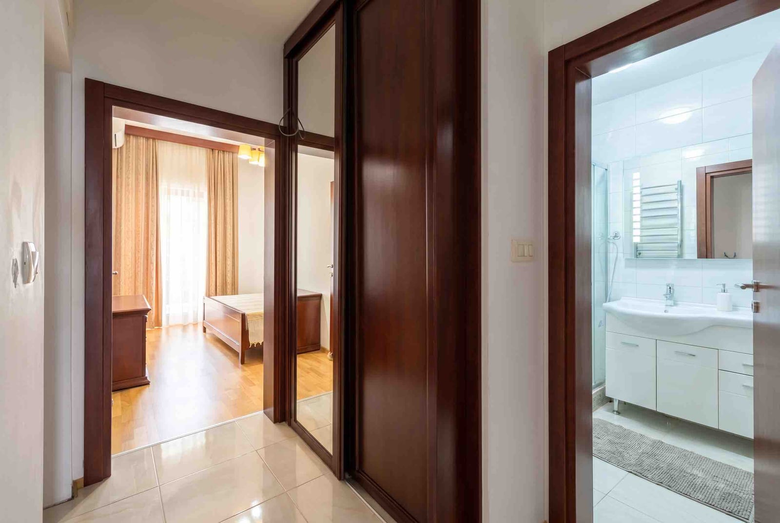 Corridor with a mirrored wardrobe and entrance to the bedroom and bathroom in an apartment, Bečići, Montenegro.