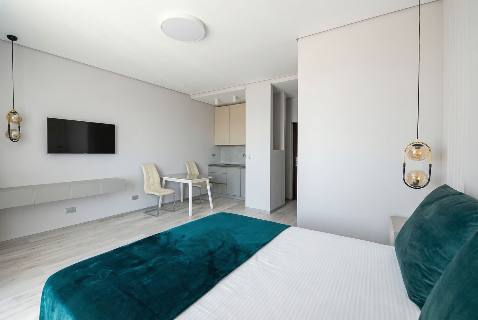 Modernes Schlafzimmer mit Küche in einer Wohnung, Bečići, Montenegro: Doppelbett, Essbereich und stilvolles Interieur.