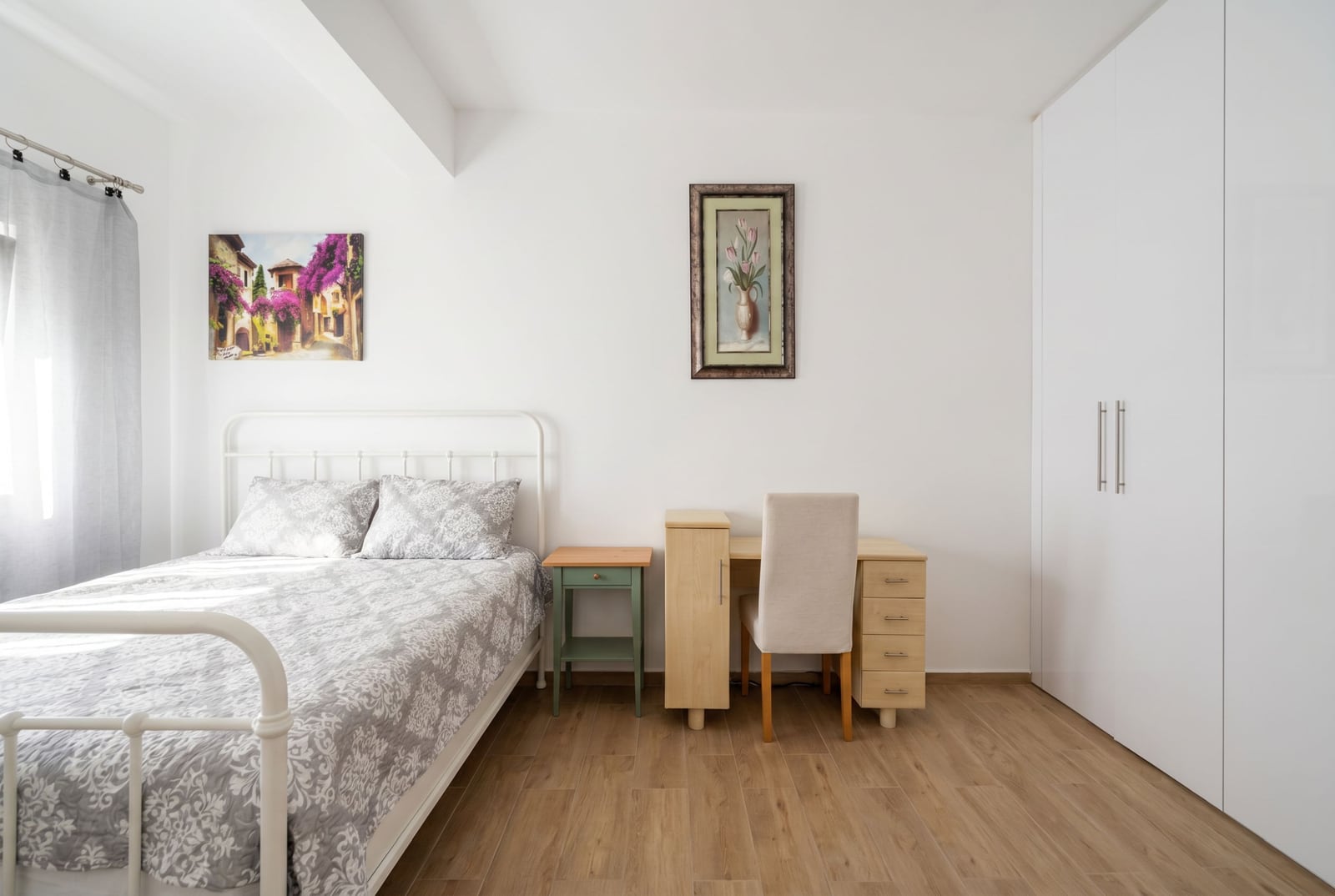 Bright bedroom with a white bed, desk, and wardrobe in an apartment in Herceg Novi, Montenegro.