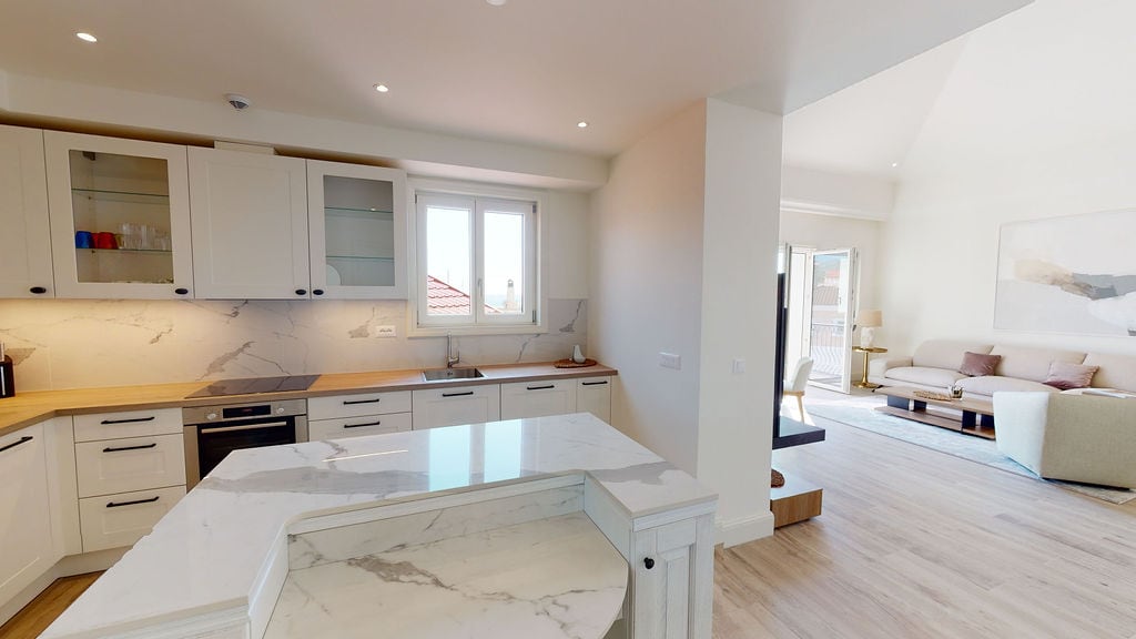 Modern kitchen with a marble countertop and white cabinetry in an apartment at Luštica residential complex, Montenegro.