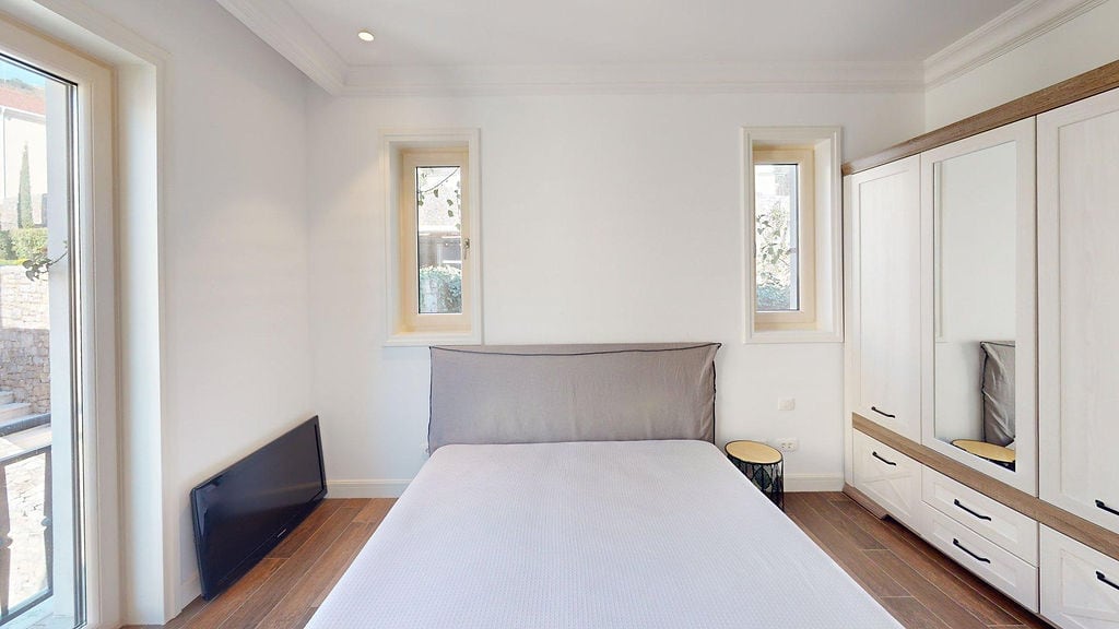 Bright bedroom with a double bed and wardrobe in an apartment, Luštica, Montenegro: modern interior with terrace access