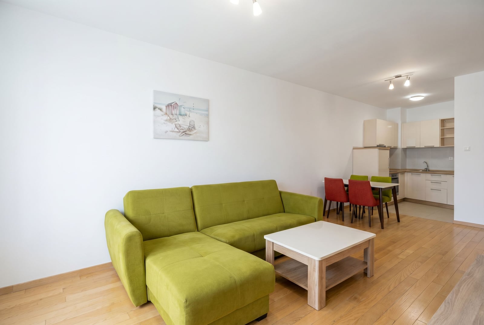 Living room with a green sofa and kitchen in an apartment in Budva, Montenegro: modern interior with a dining area.