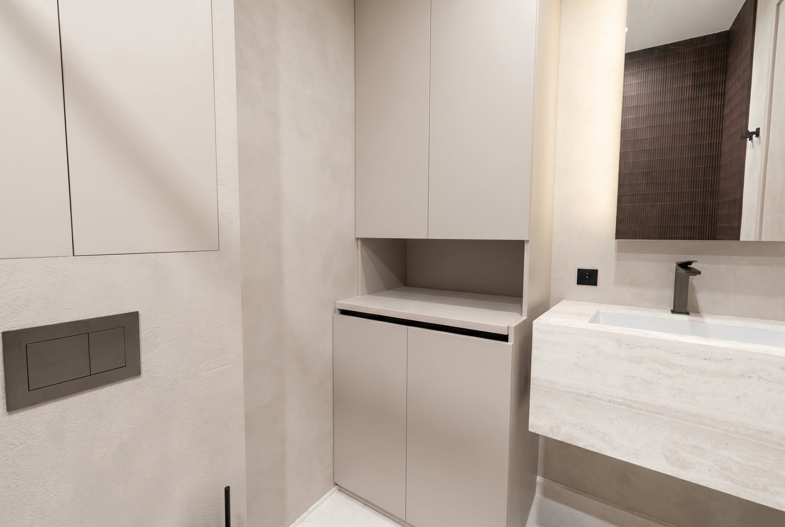 Modern bathroom in an apartment in Tivat, Montenegro: stone sink, built-in cabinet, and stylish finishes.