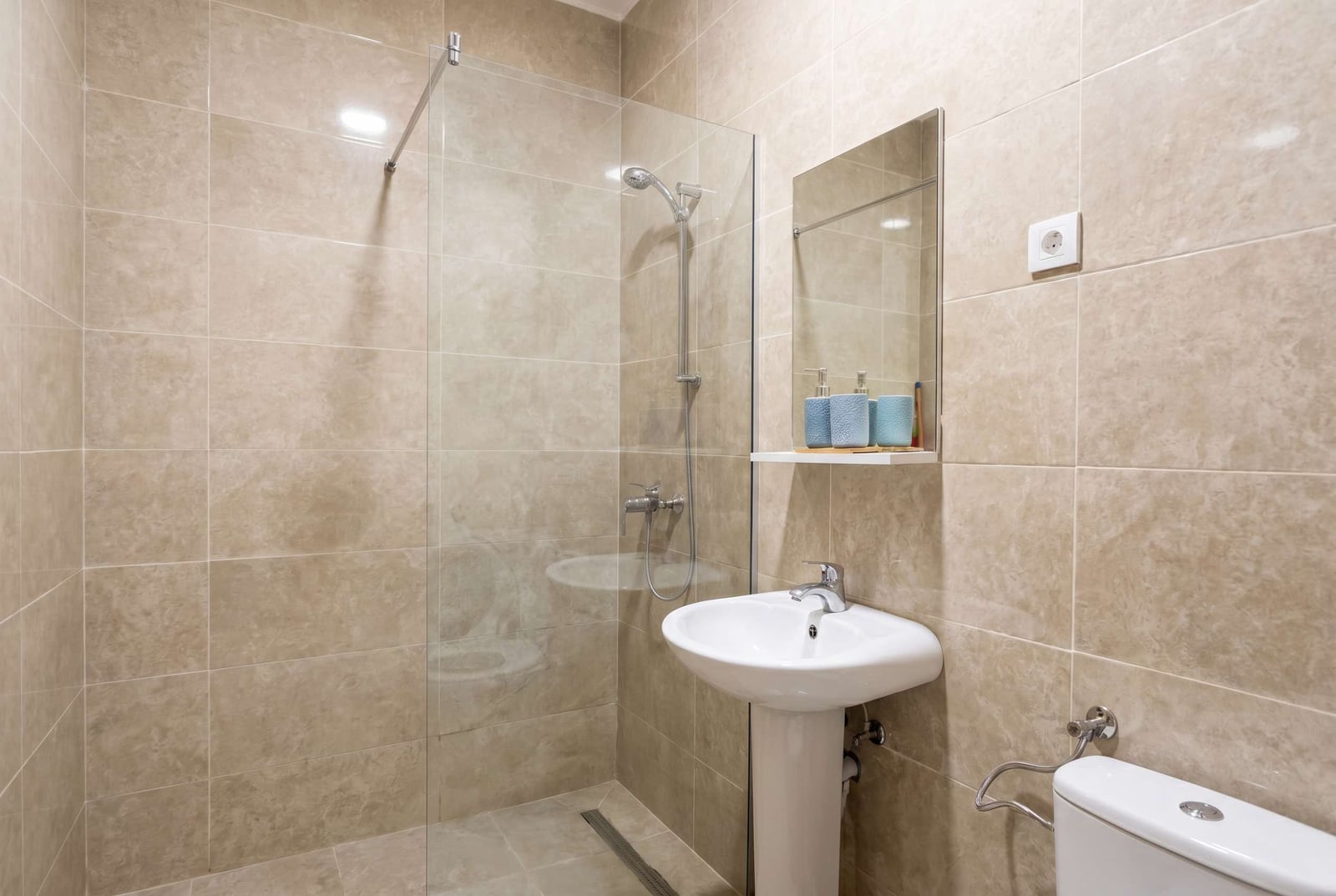 Modern bathroom with a shower cabin and white sanitary ware in an apartment in Budva, Montenegro.