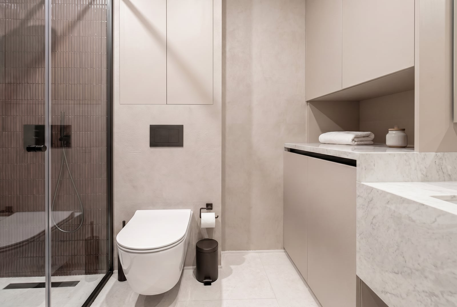 Modern bathroom in an apartment in Tivat, Montenegro: shower cabin, marble countertop, and stylish furniture.