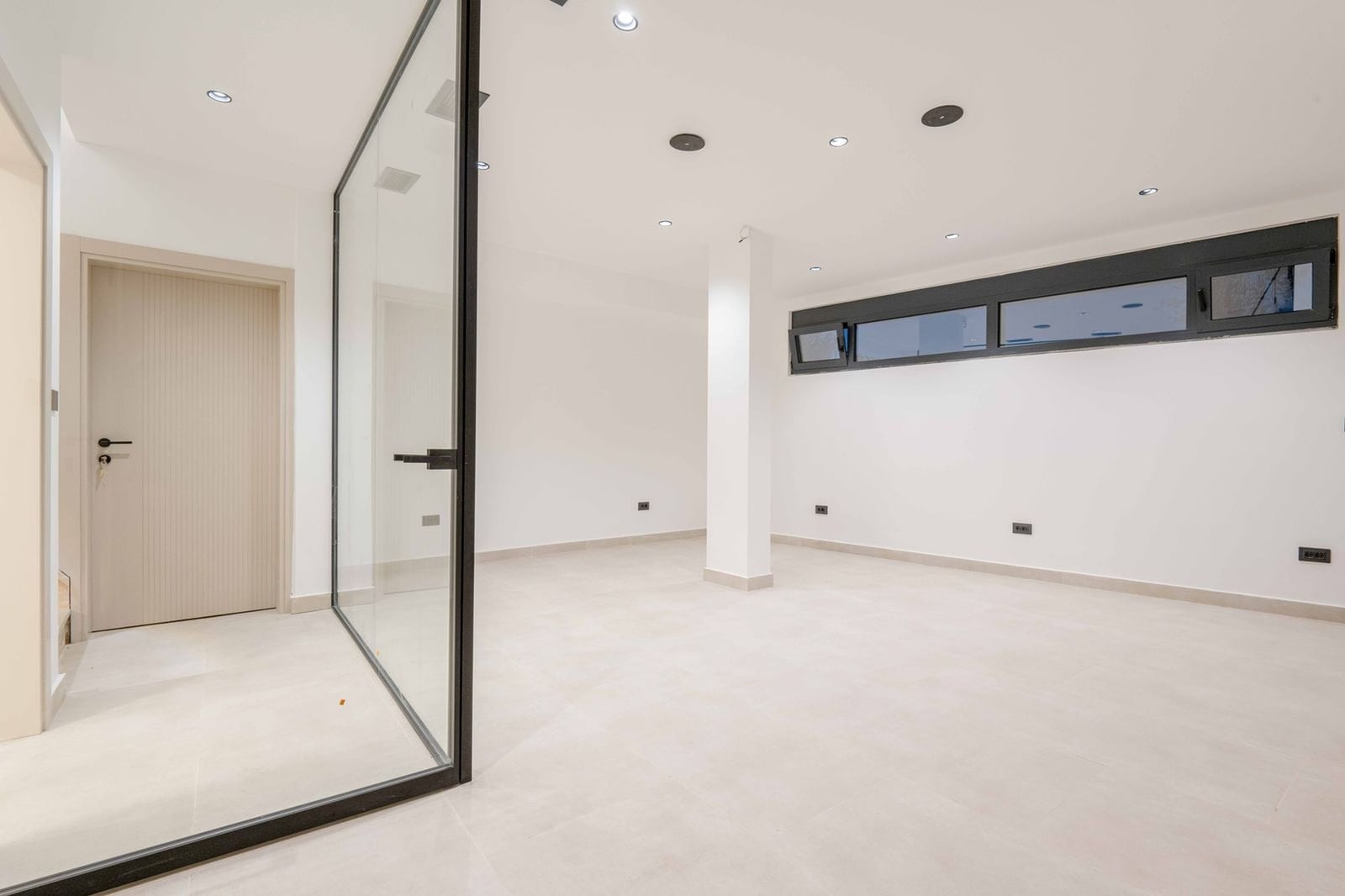 Salon moderne avec cloison vitrée panoramique dans une villa à Kamenovo, Monténégro : intérieur lumineux, carrelage.