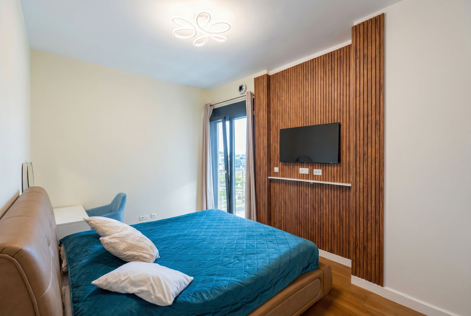Modern bedroom with a double bed and wooden panels in an apartment, Bar, Montenegro.
