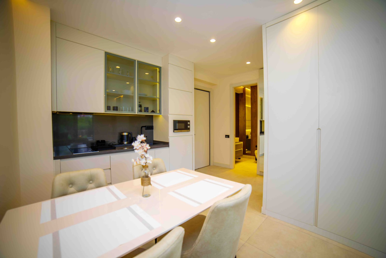 Modern kitchen-dining room in an apartment in Bečići, Montenegro: light-colored kitchen set, dining area, and built-in appliances.