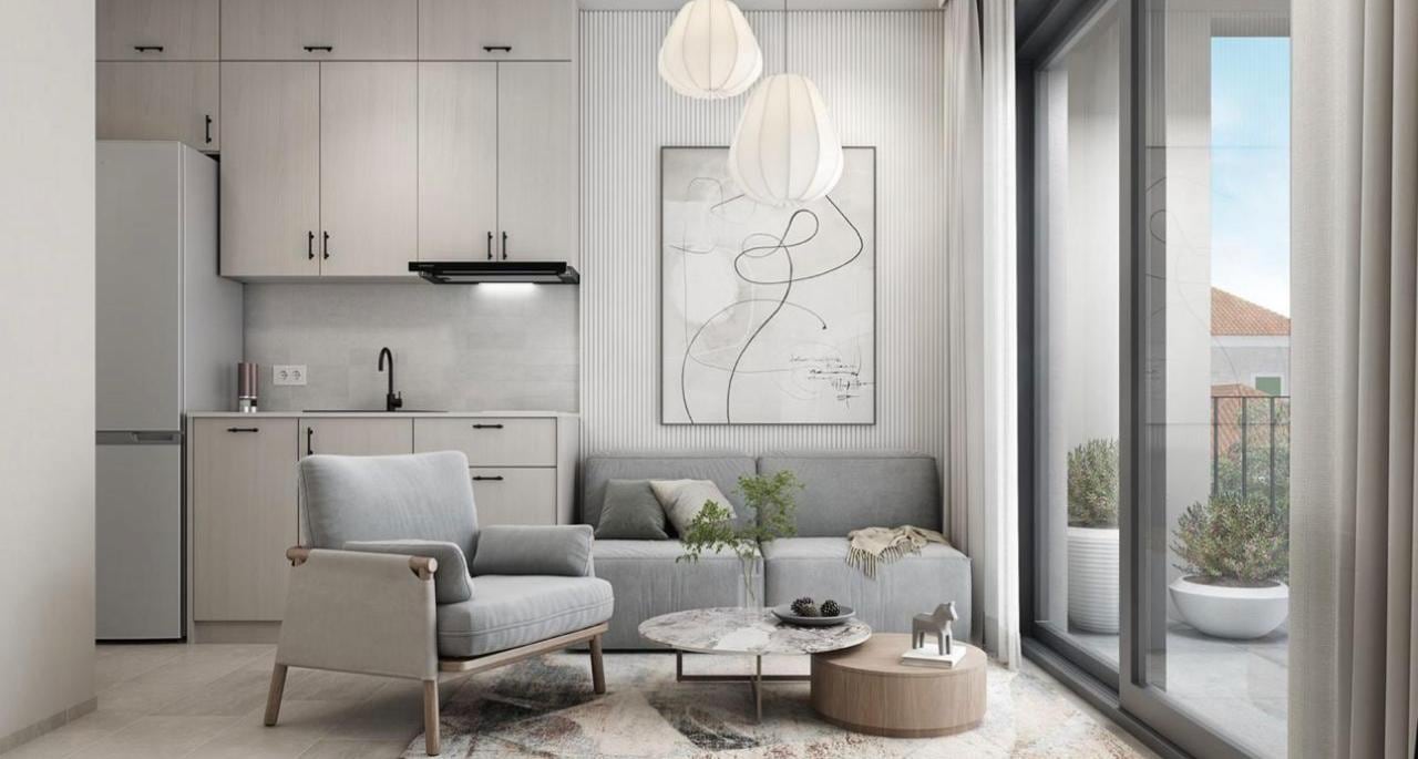 Modern living room with kitchen in the Herceg Novi residential complex, Montenegro: light furniture, panoramic windows, and access to the terrace.