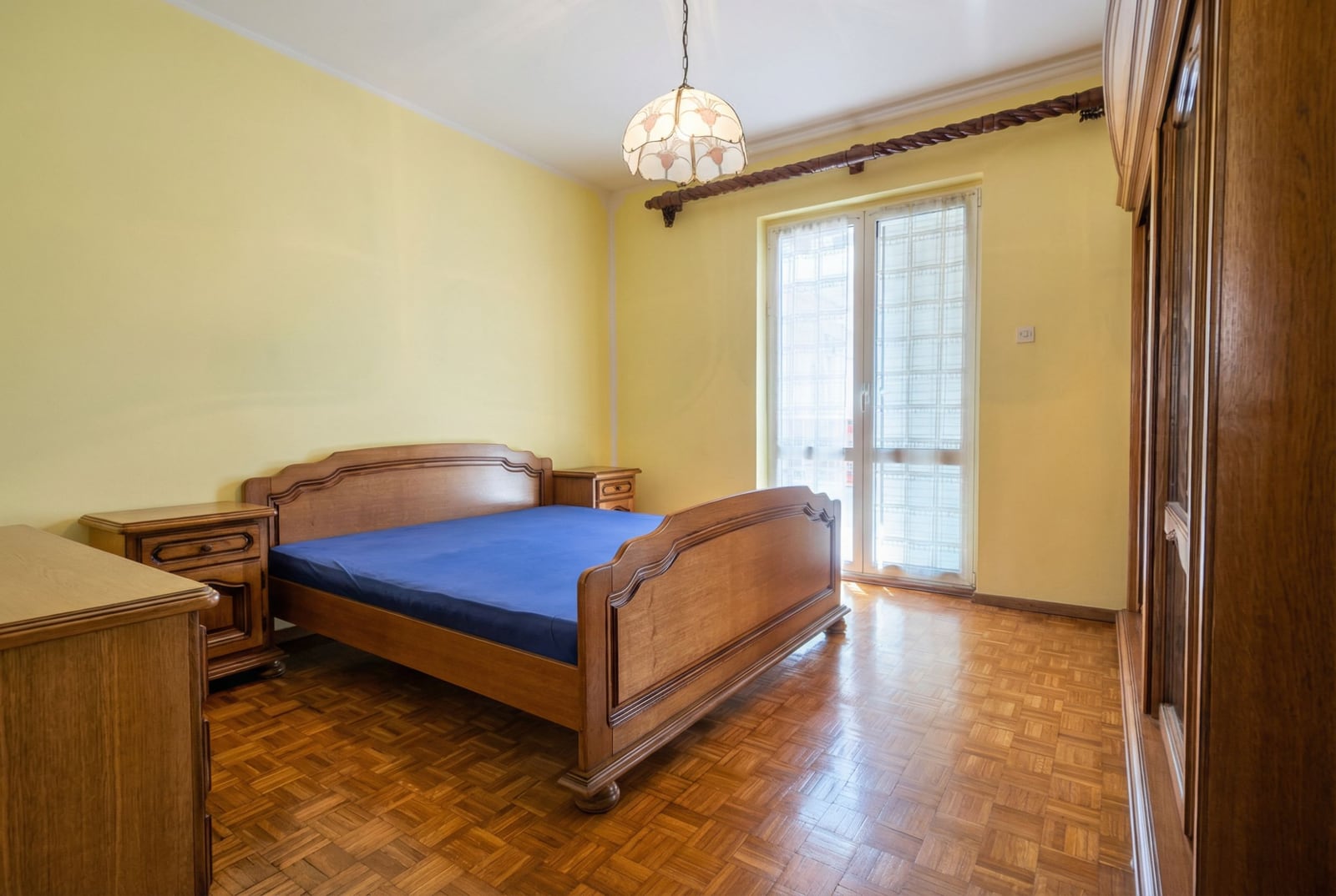 Bedroom with a double bed, parquet flooring, and access to the balcony in a house for sale, Herceg Novi, Montenegro.