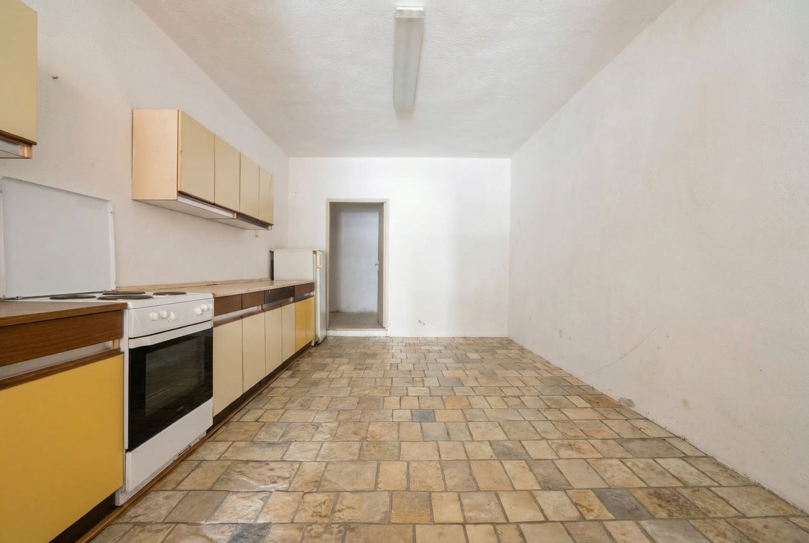 Kitchen in a house in Herceg Novi, Montenegro: a bright room with stone flooring, kitchen cabinets, and a stove.