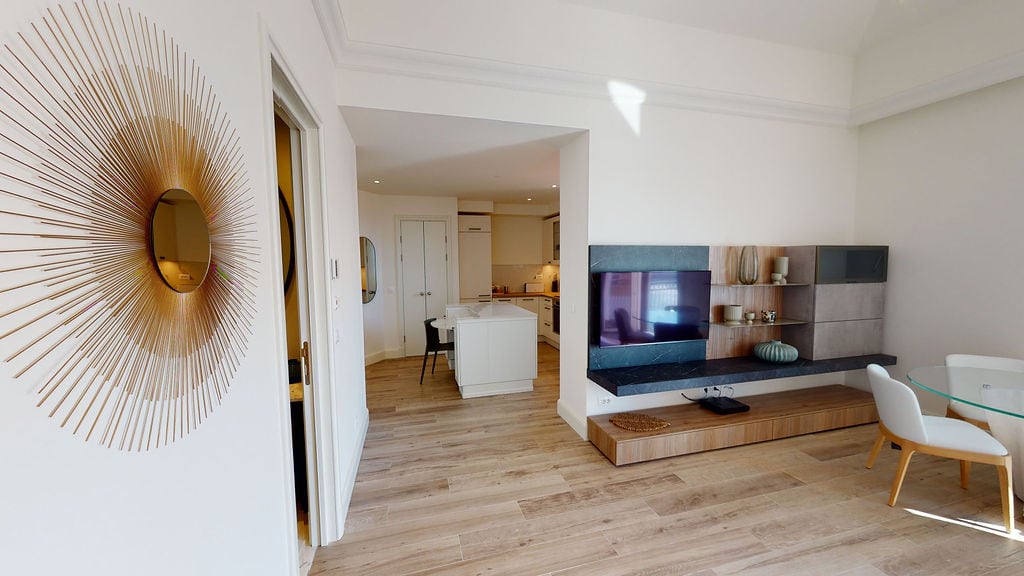 Modern living room with kitchen in an apartment, Luštica, Montenegro: stylish interior, TV area, and dining set.