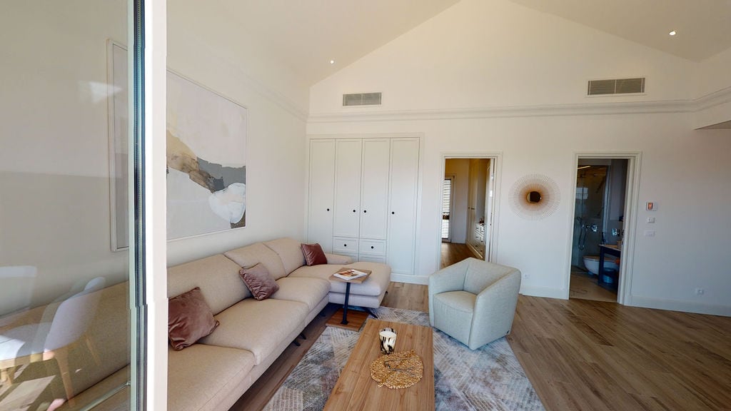 Modern living room in an apartment, Luštica, Montenegro: bright interior, corner sofa, high ceilings, and parquet flooring.