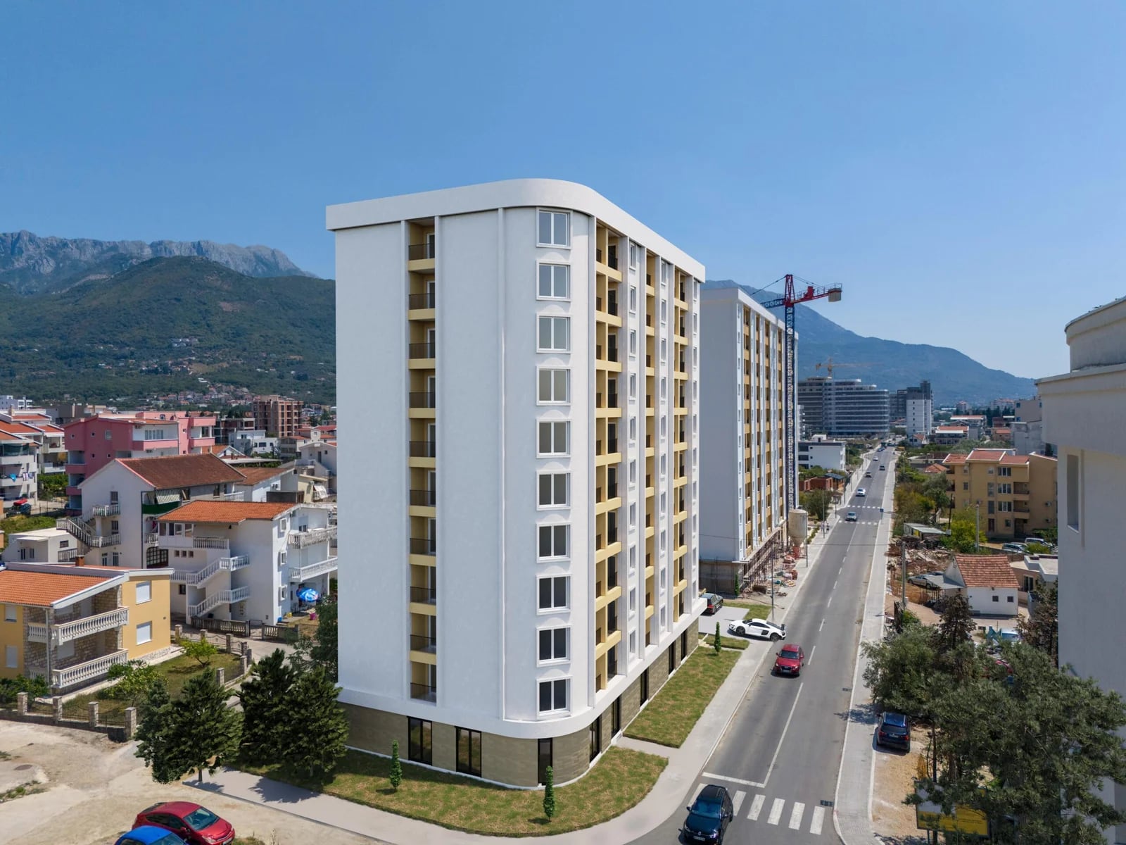 Karadağ’ın Bar şehrindeki modern konut kompleksi: balkonlu çok katlı bina ve dağ manzarası.