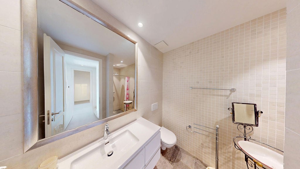 Modern bathroom with white fixtures and mosaic tiles in an apartment, Luštica, Montenegro.