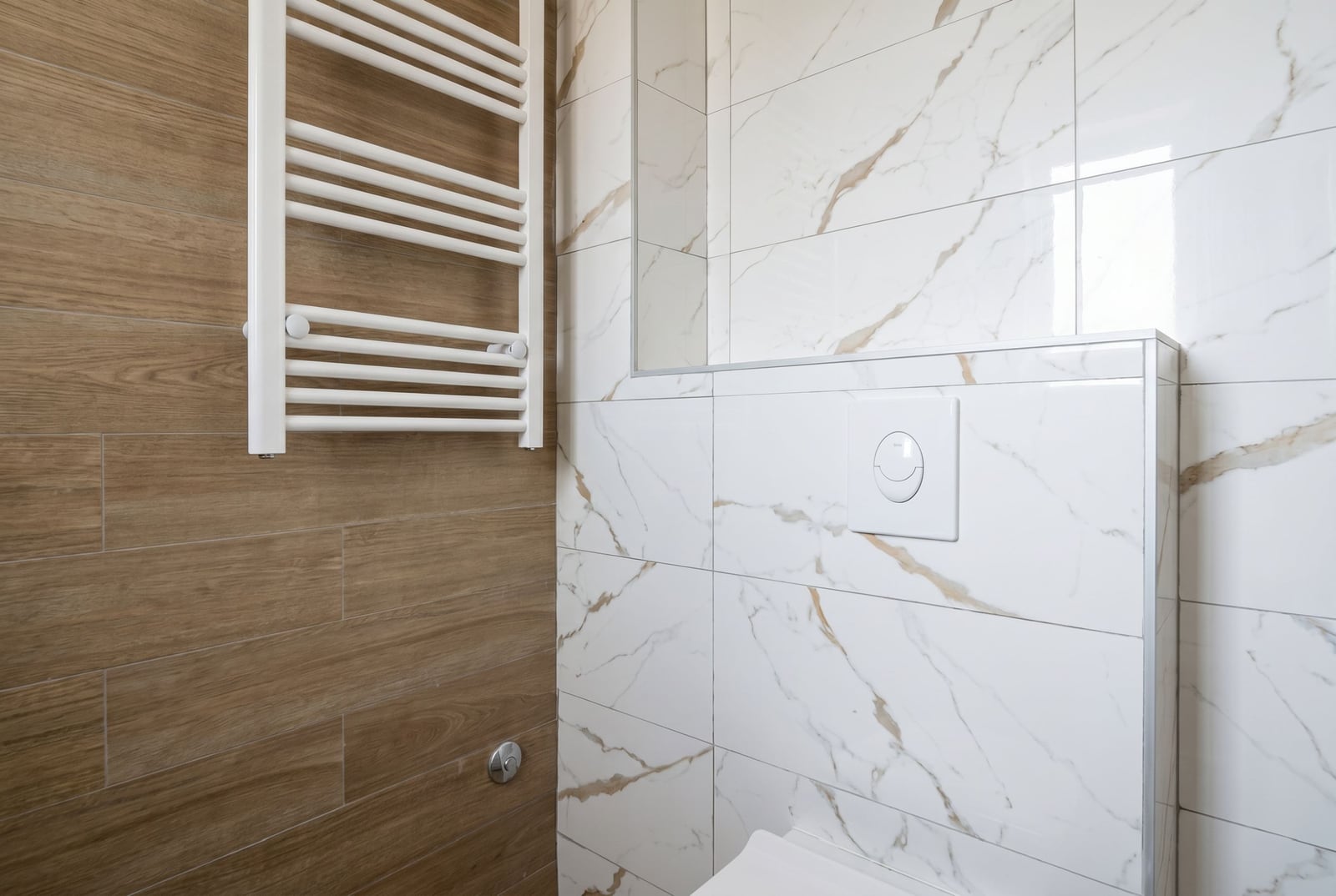 Modern bathroom in an apartment, Herceg Novi, Montenegro: white marble-look tiles and wood finishes.