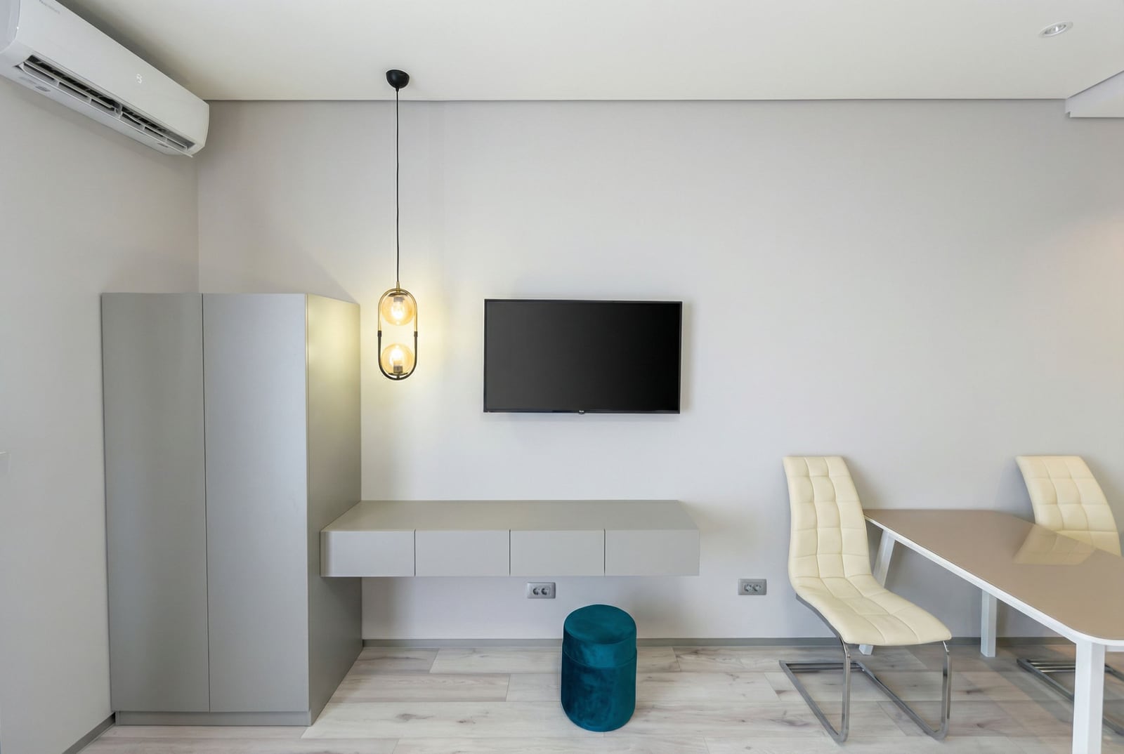 Modernes Wohnzimmer in einer Wohnung, Bečići, Montenegro: TV-Bereich, hängendes Sideboard, stilvolle Stühle und Klimaanlage.