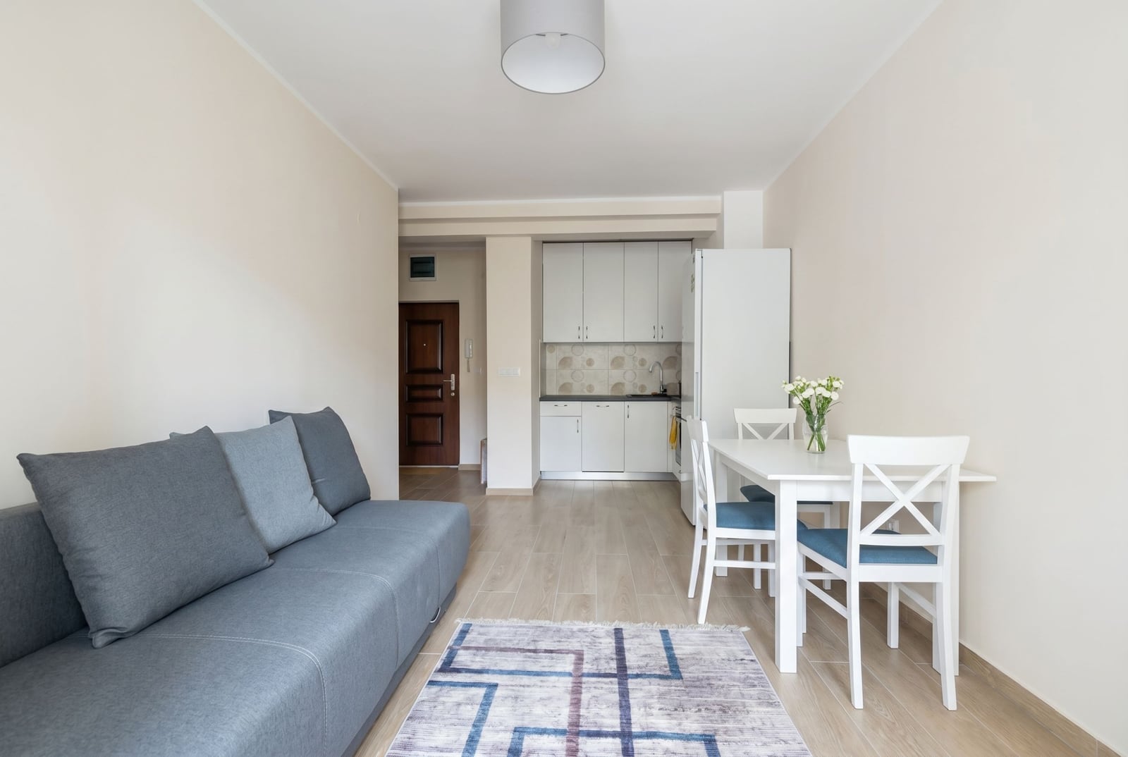 Living room with kitchen in an apartment in Herceg Novi, Montenegro: gray sofa, dining area, and light modern finishes.