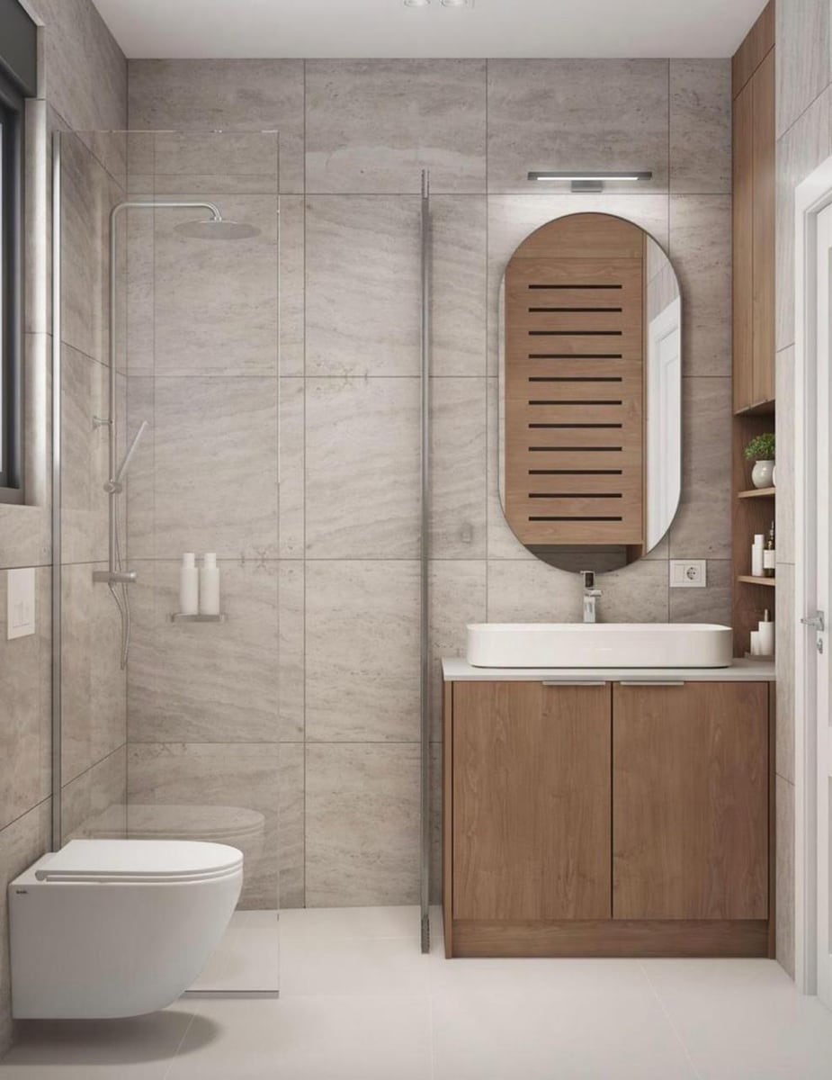 Modern bathroom in the Herceg Novi residential complex, Montenegro: shower cabin, vanity unit, and a stylish oval mirror.
