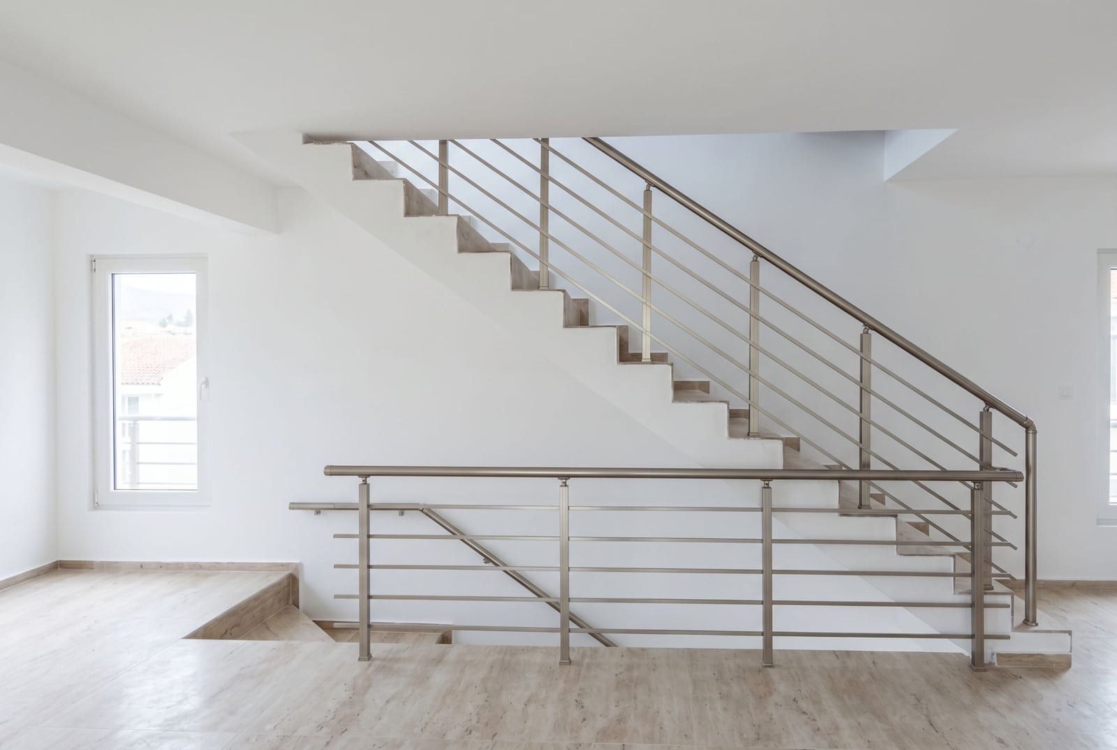 Modern staircase with metal railings in an apartment interior in Đenovići, Montenegro, light finishes.
