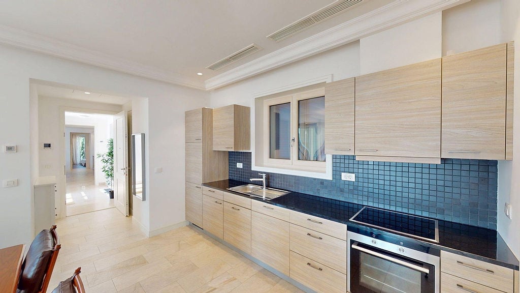 Modern kitchen with wooden facades and a black backsplash in an apartment, Luštica, Montenegro.