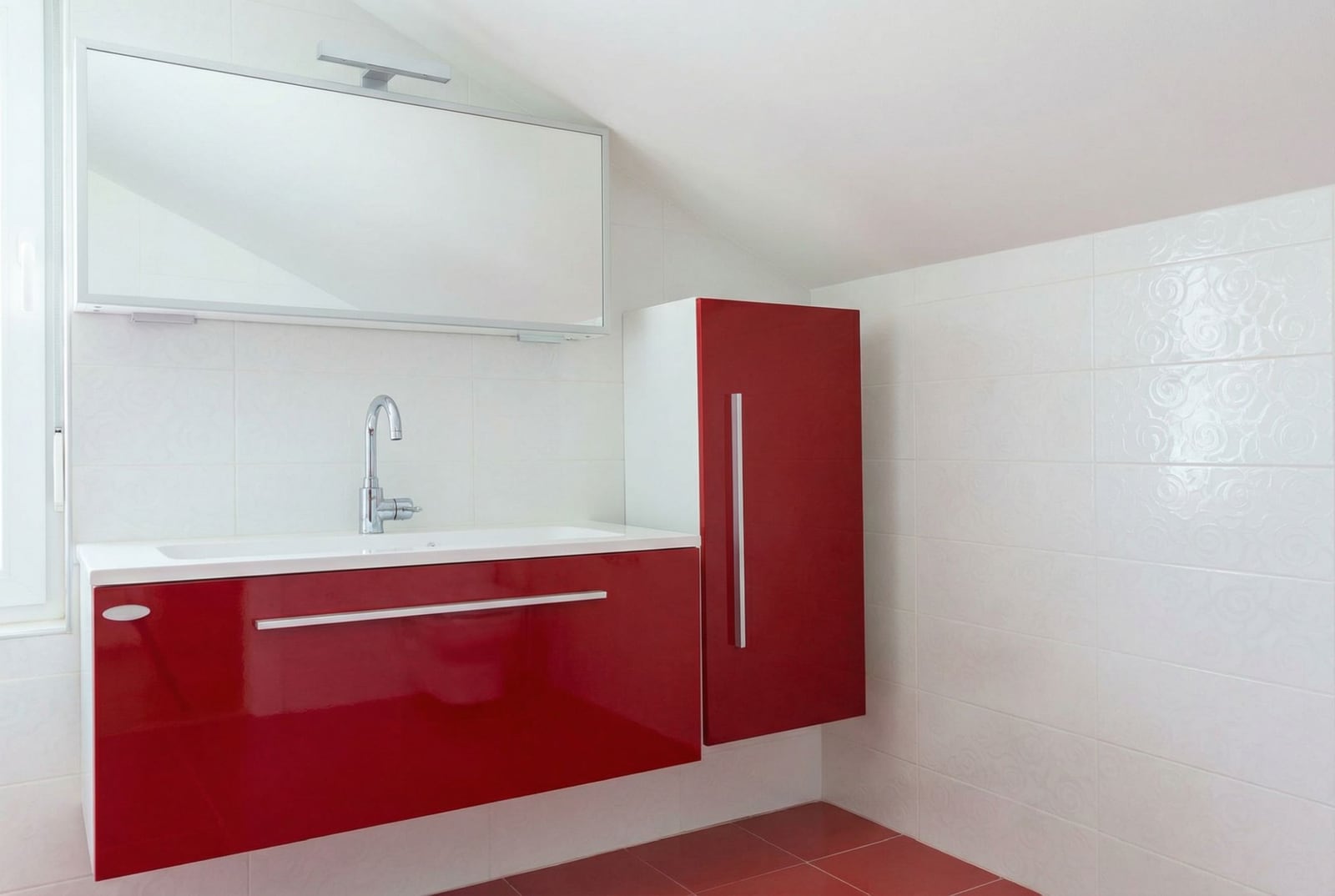Modern bathroom with red furniture in a house in Herceg Novi, Montenegro: white tiles and a stylish sink.