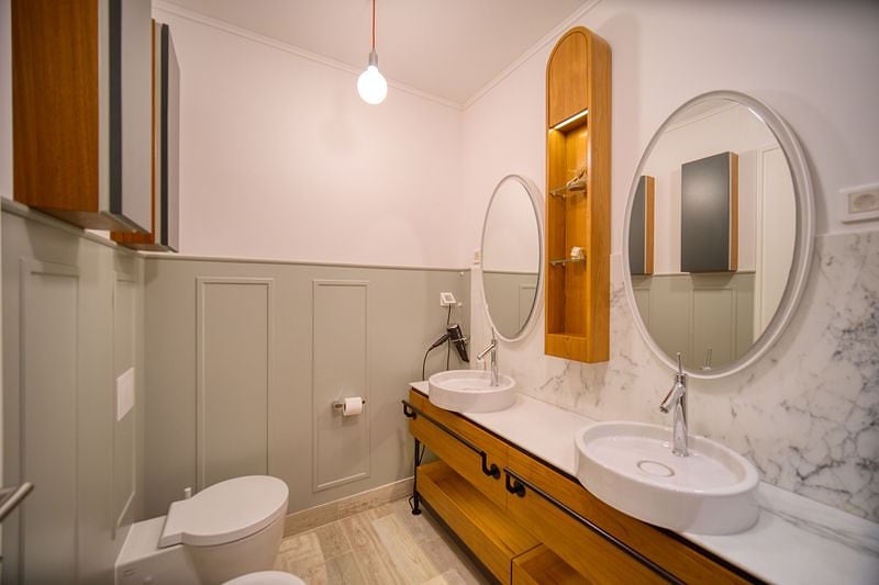 Modern bathroom with two sinks in an apartment in Luštica, Montenegro: marble finishes and wooden furniture.