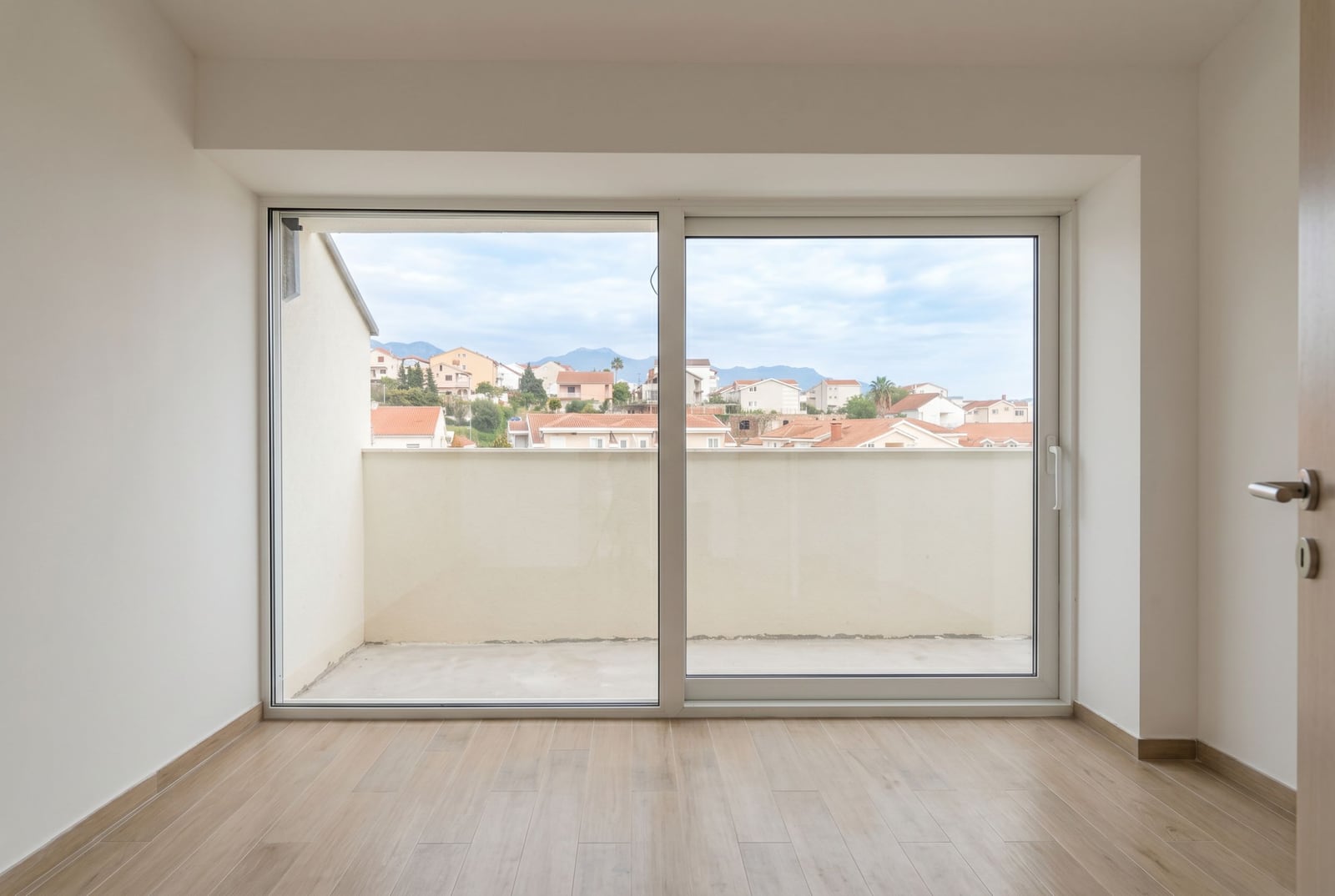 Bright living room with a panoramic window and access to the balcony in an apartment, Đenovići, Herceg Novi, Montenegro.