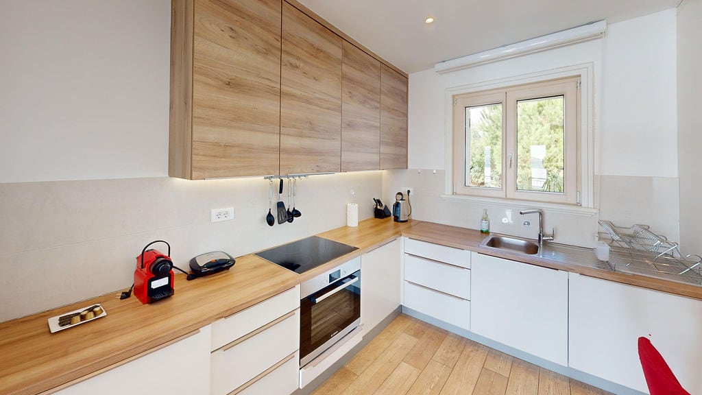 Modern kitchen with wooden fronts and built-in appliances in an apartment, Krašići, Montenegro.