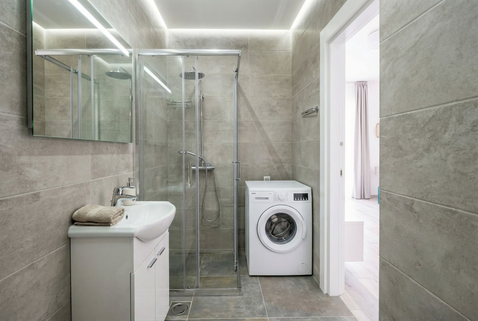 Modernes Badezimmer mit Duschkabine und Waschmaschine in der Wohnung, Bečići, Montenegro.