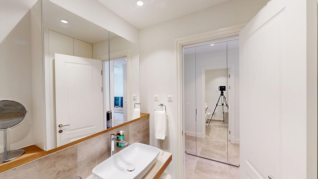 Modern bathroom in an apartment at Luštica Bay, Montenegro: stylish fixtures, mirrors, and light finishes.