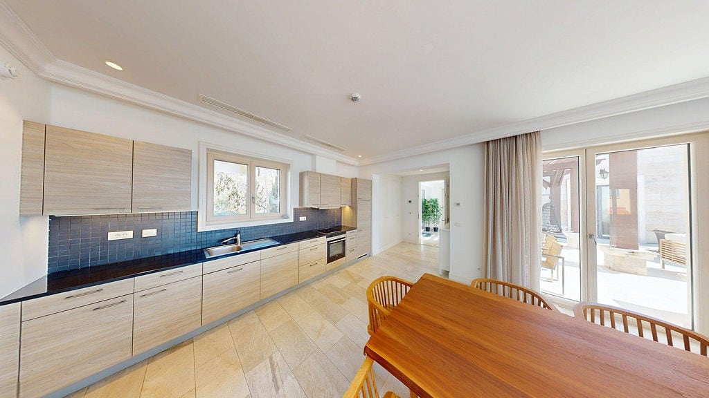 Modern kitchen with wooden furniture and terrace access in a residential complex, Luštica, Montenegro.