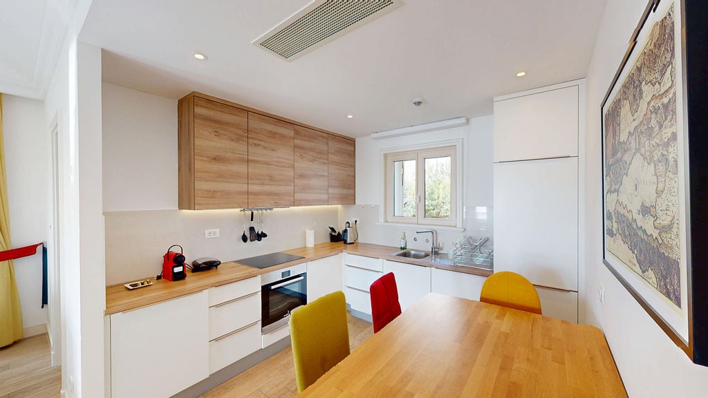 Modern kitchen with wooden facades and dining area in an apartment, Krašići, Montenegro.