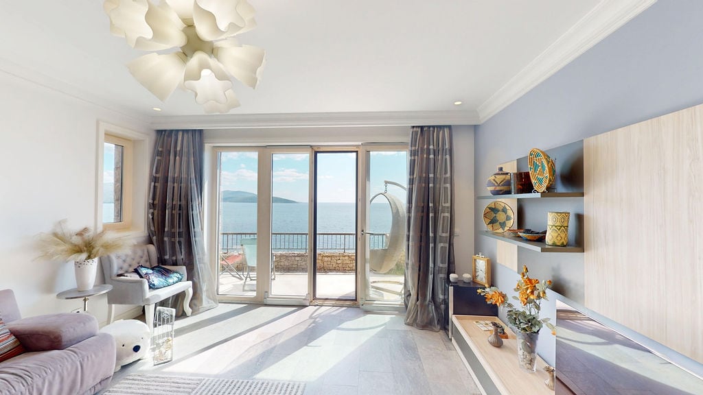 Living room with panoramic sea view in an apartment, Luštica, Montenegro: modern furniture, terrace, and stylish decor.