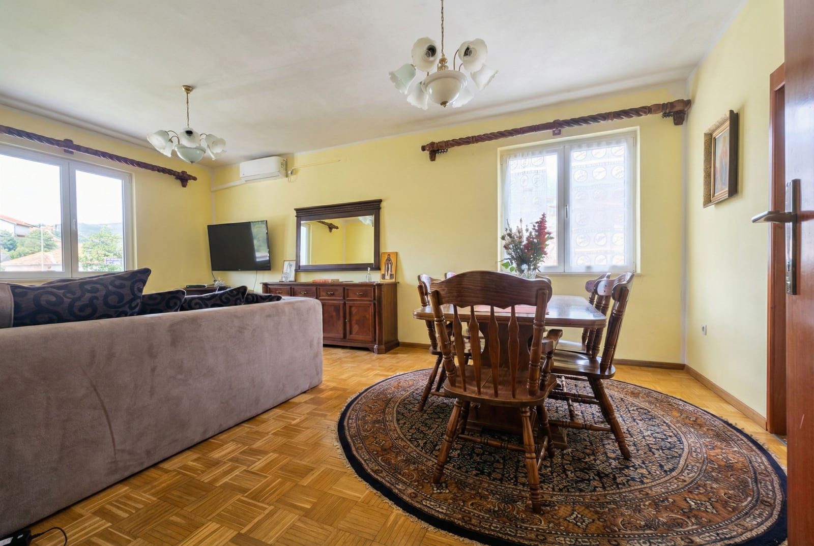 Living room in a house in Herceg Novi, Montenegro: wooden furniture, parquet flooring, dining area, and a soft sofa in the interior.