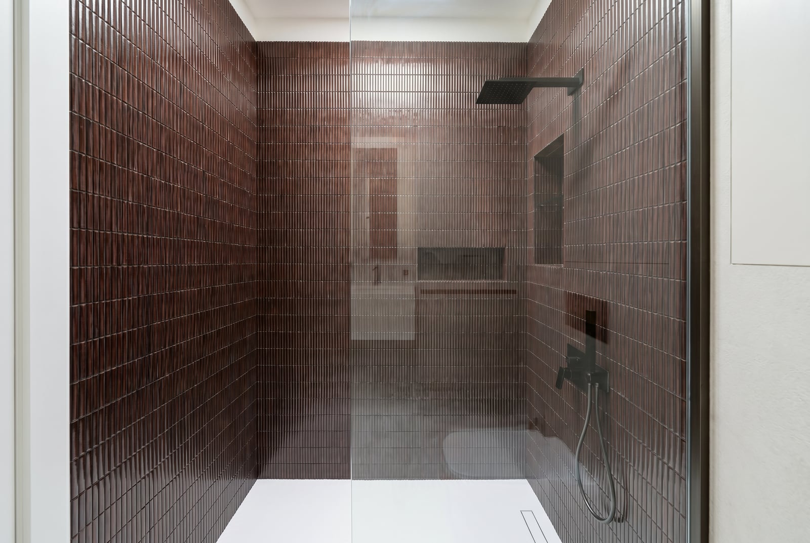 Modern shower cabin with brown textured tiles in an apartment, Tivat, Montenegro.