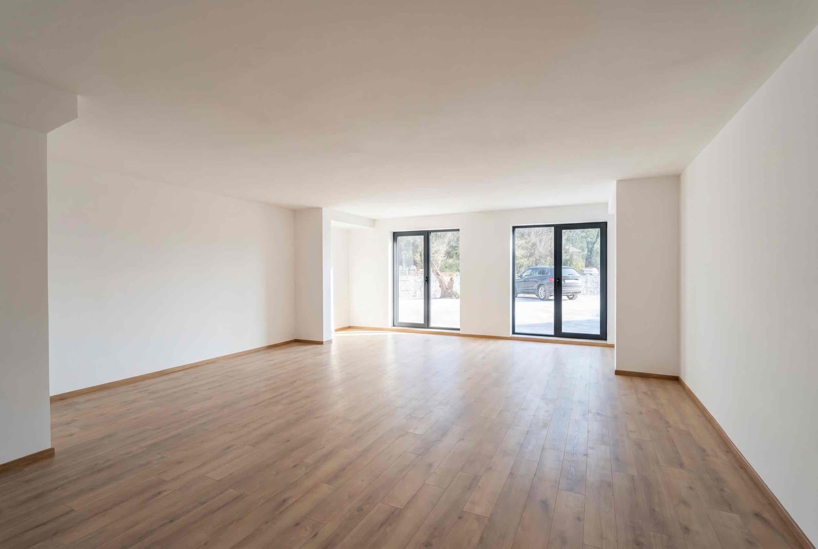 Spacious bright living room with laminate flooring and panoramic windows in an apartment in Pržno, Montenegro.