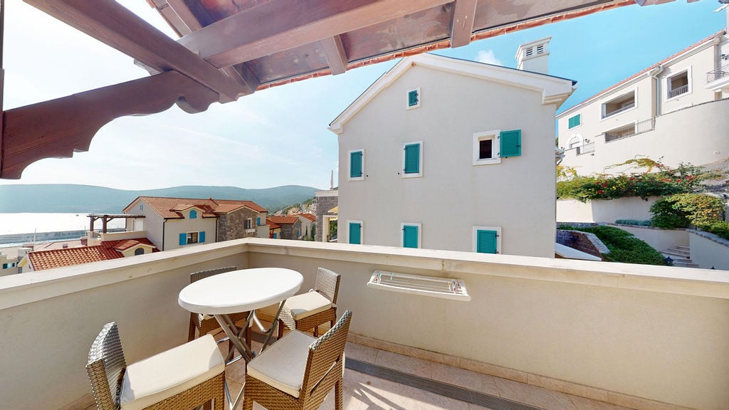Balcony with wicker furniture and sea view in a residential complex, Krašići, Montenegro.