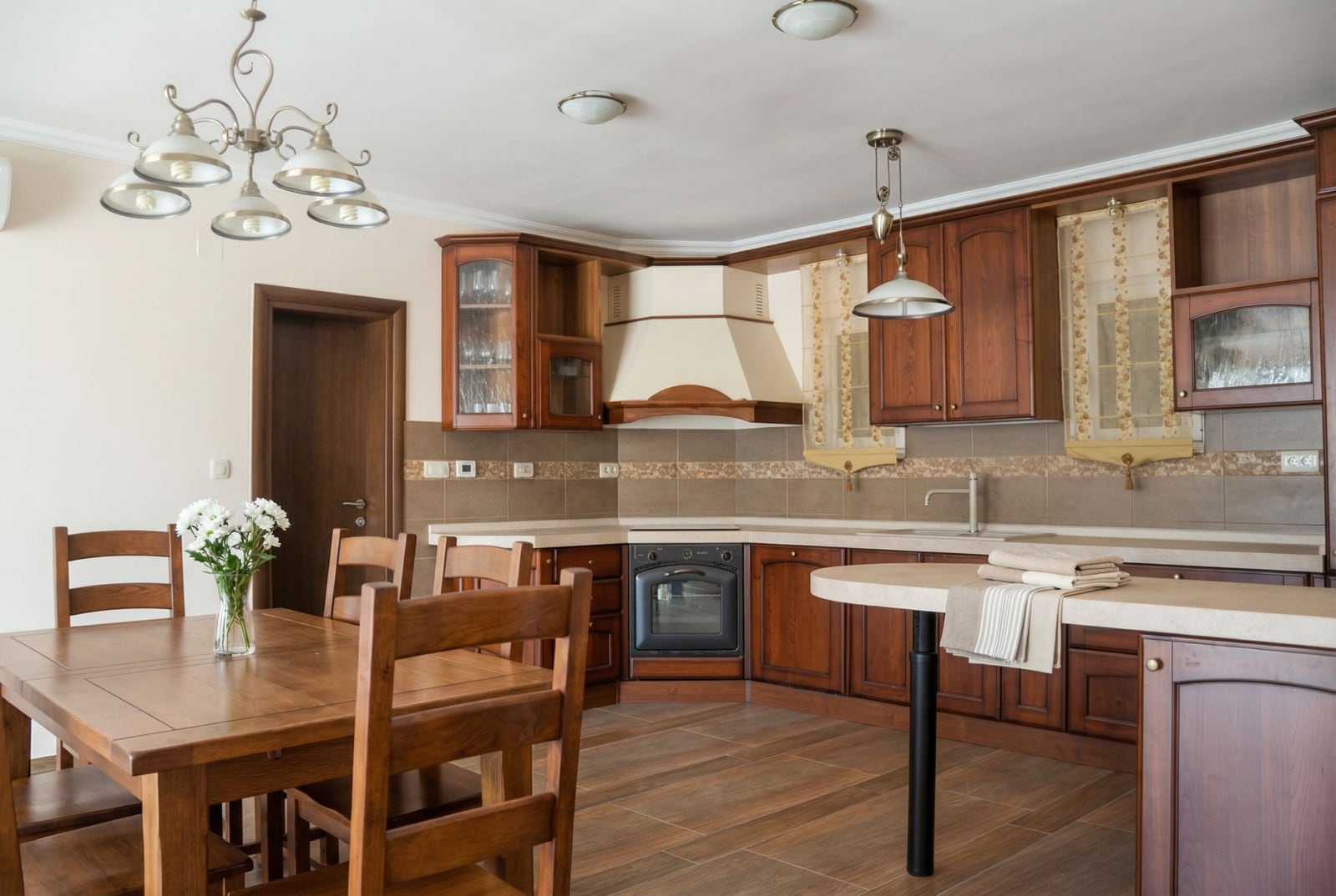 Spacious kitchen with wooden cabinetry and dining area in a house, Herceg Novi, Montenegro.