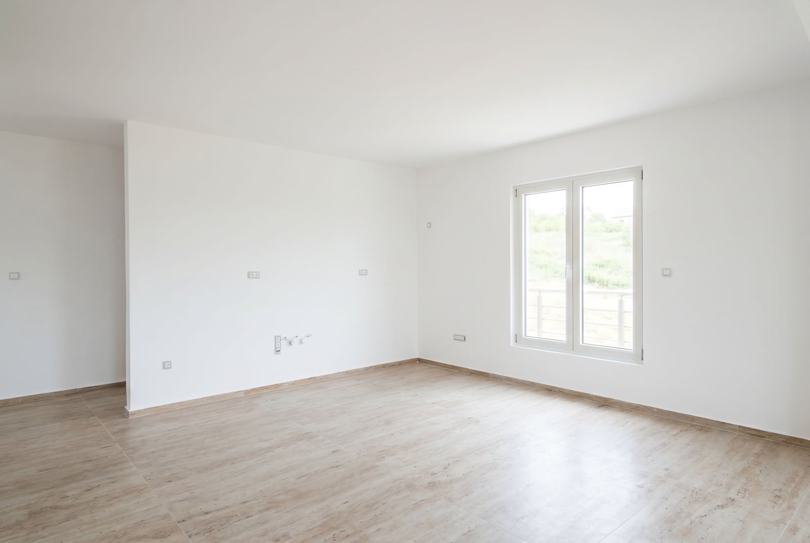Bright empty living room with white walls and tiled floor in an apartment in Đenovići, Herceg Novi, Montenegro.