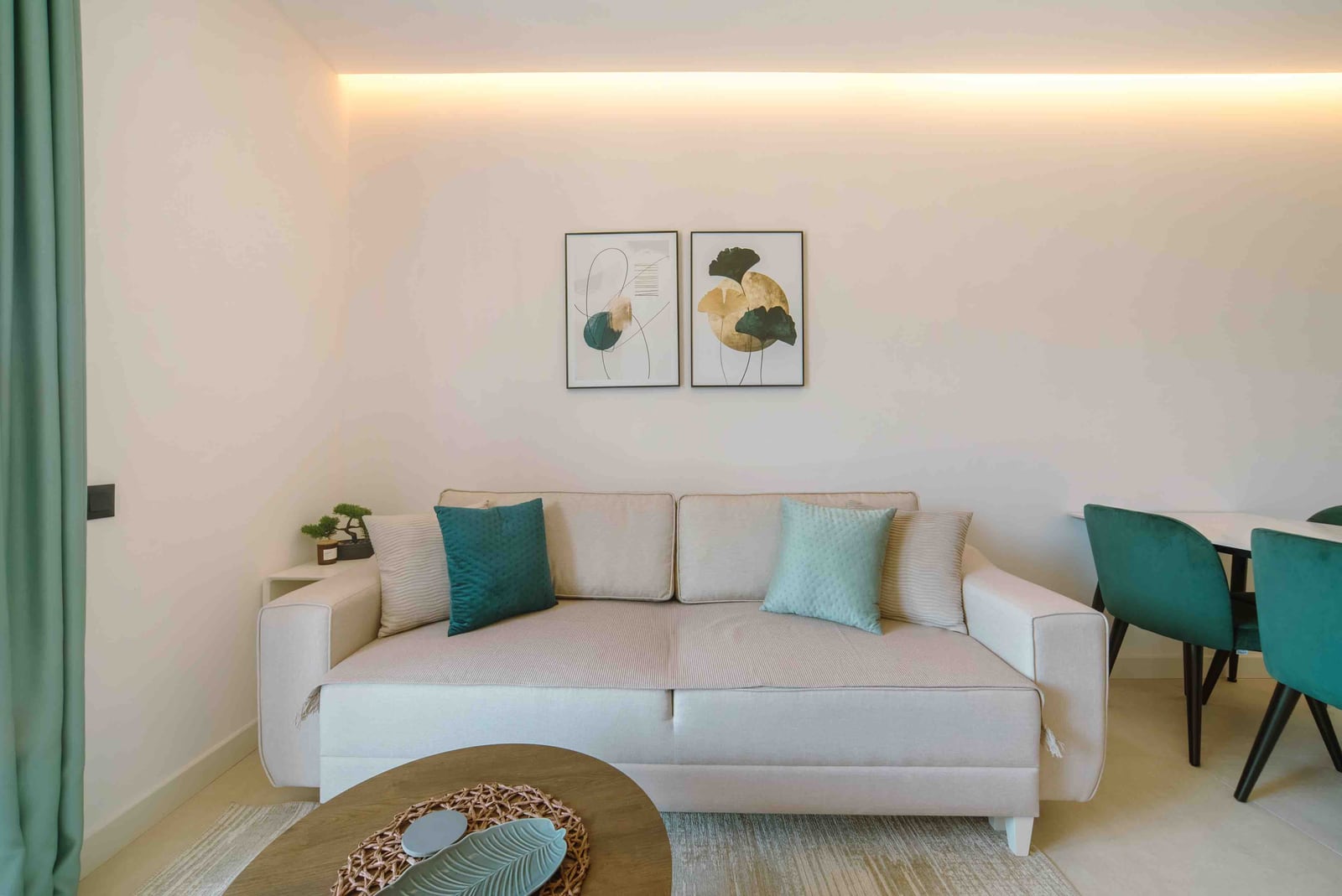 Bright living room with a beige sofa in a modern apartment in Bečići, Montenegro, featuring designer decor and accent lighting.