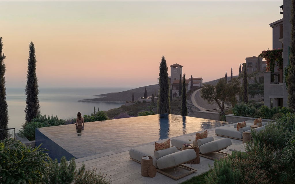 Infinity pool with sea view in the elite residential complex Luštica, Montenegro, with a lounge area and sun loungers.