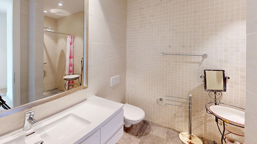 Modern bathroom with a shower and light-colored tiles in an apartment at Luštica Bay, Montenegro.