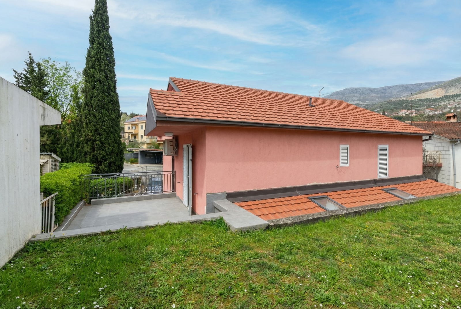 Pink house with a tiled roof and terrace in Herceg Novi, Montenegro: view of the plot and building facade.
