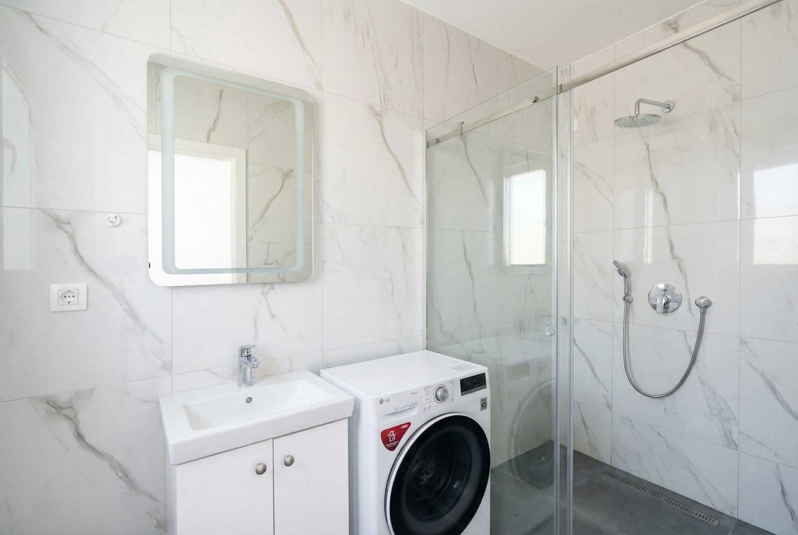 Modern bathroom with a shower cabin and washing machine in an apartment, Bar, Montenegro.