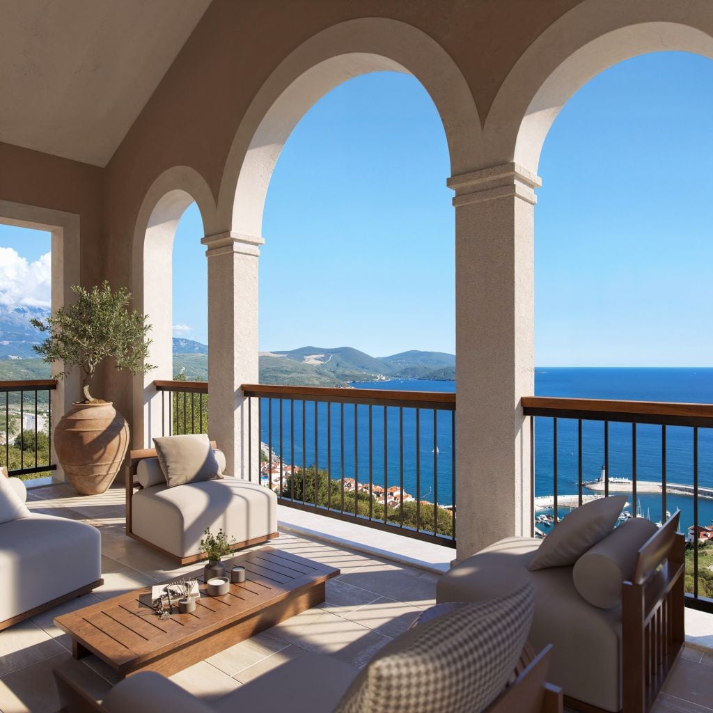 Terrace with arched openings and sea view in the Luštica residential complex, Montenegro: soft furniture and decor.