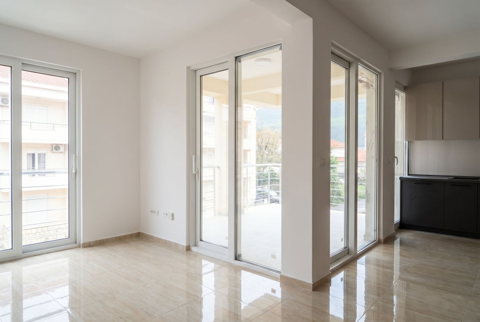 Bright living room with panoramic windows and kitchen in a new apartment in Herceg Novi, Montenegro.