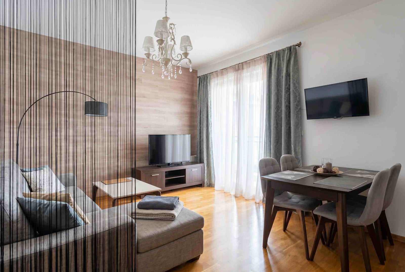 Living room in an apartment in Budva, Montenegro: modern furniture, dining area, parquet flooring, and stylish wall finishes.