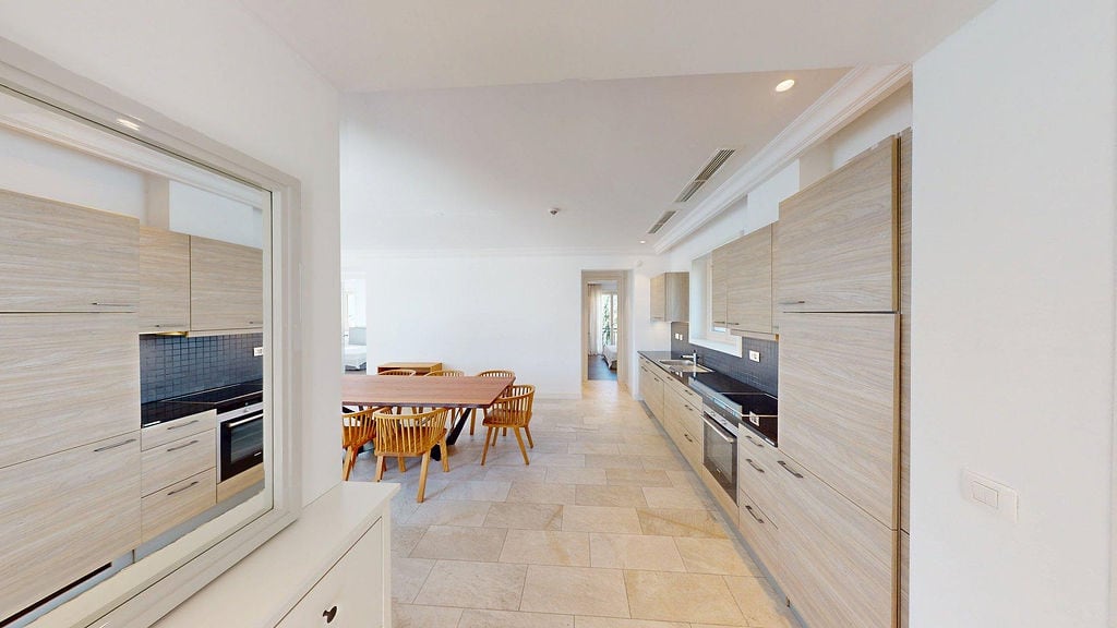 Modern kitchen with wooden facades and dining area in an apartment, Luštica, Montenegro.